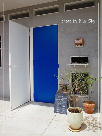 『白い壁と青い扉の家が海に映えるシティ・ブ・サイド』シデ 